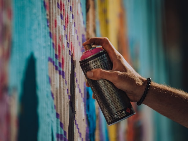 artist spray painting wall