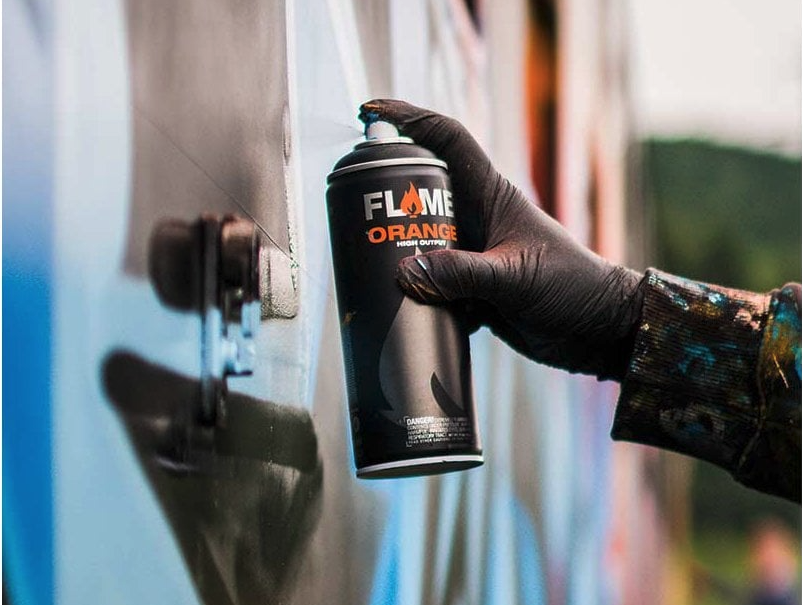 Flame Orange spray paint being used by a graffiti artist