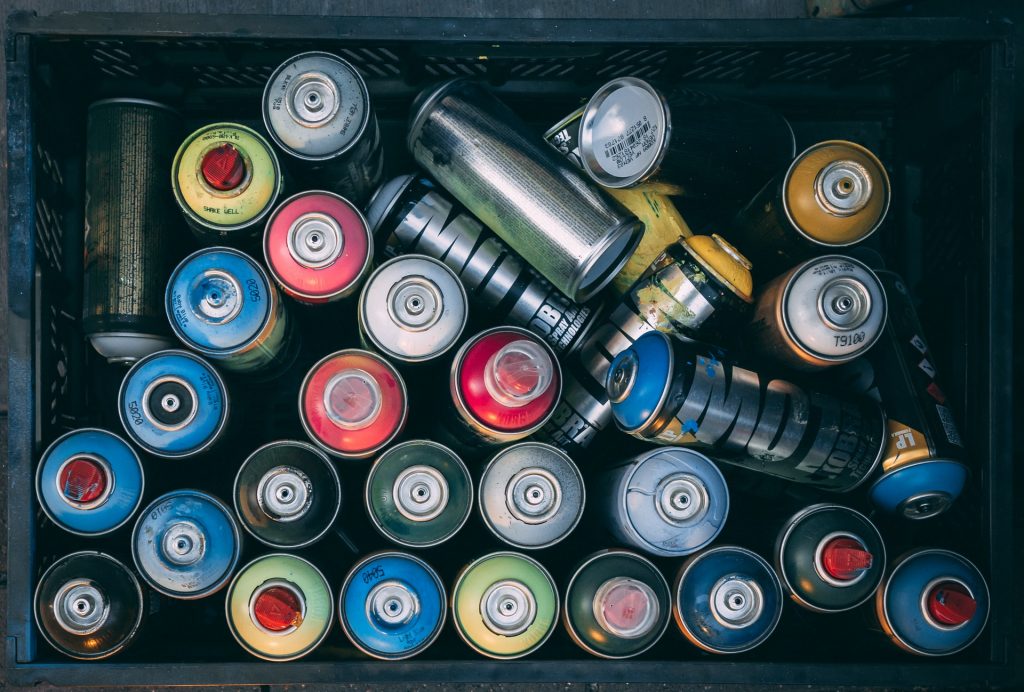 various spray paint cans in a box