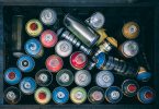 various spray paint cans in a box