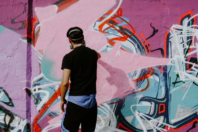 graffiti artist painting using a respirator