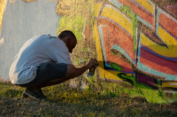 graffiti artist painting in the sun